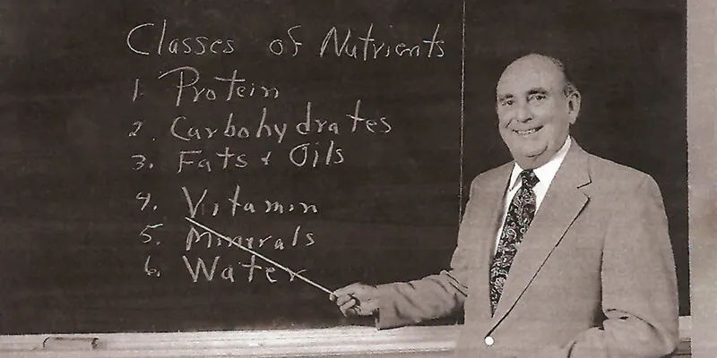 man teaching in front of a blackboard