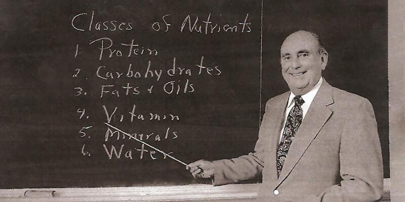 man teaching in front of a blackboard