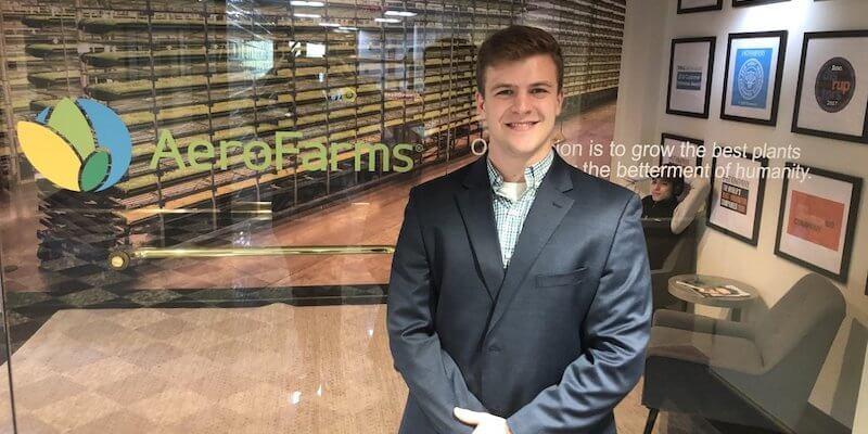 Young man stands in front of glass wall