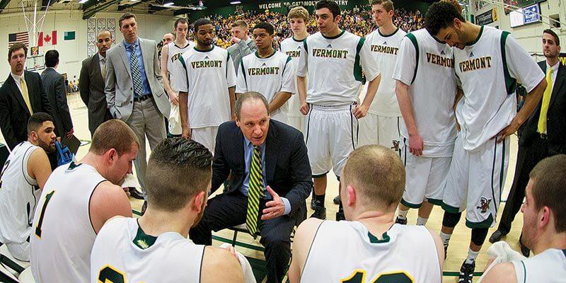 Coach John Becker talking to his players on the court