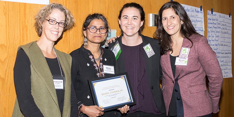 Bindu Panikkar holds award with three other women