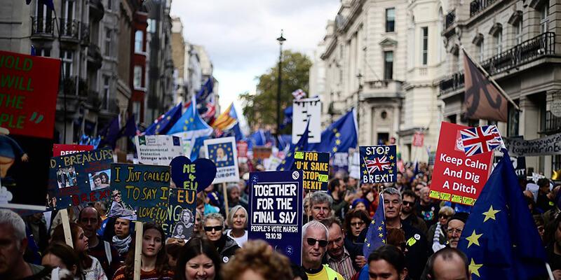 People’s Vote march protesters in the streets of London with flags and signs.