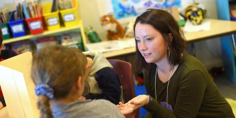 Special Education Teacher engaging with a student in a school classroom