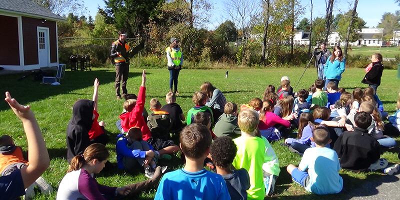 School children interact with drone operators.