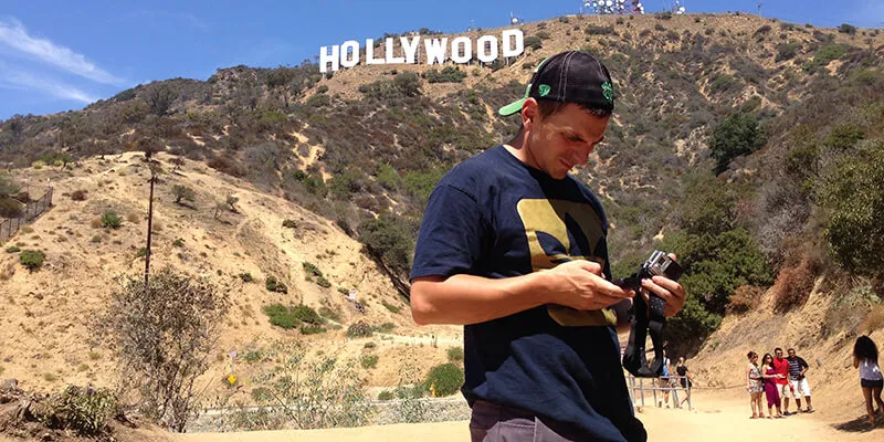 Braden Duemmler adjusts a camera below the "Hollywood' sign in Los Angeles 