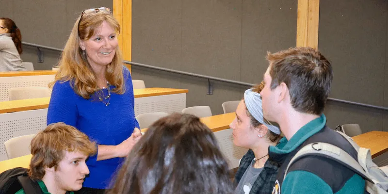 Haley Woodside-Jiron speaking with a group of students after class.