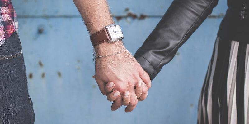 Closeup view of two people holding hands, genders unspecified