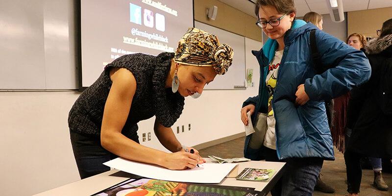 woman signing poster for student