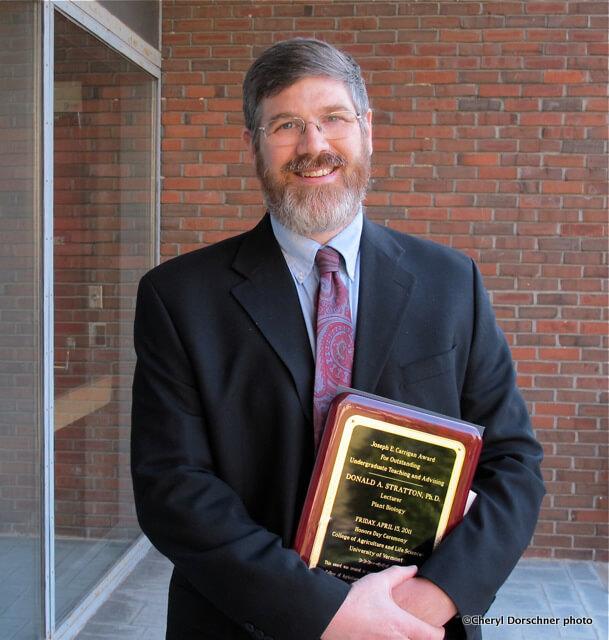 Donald Stratton holds the Joseph E. Carrigan Award for Excellence in Teaching and Undergraduate Education
