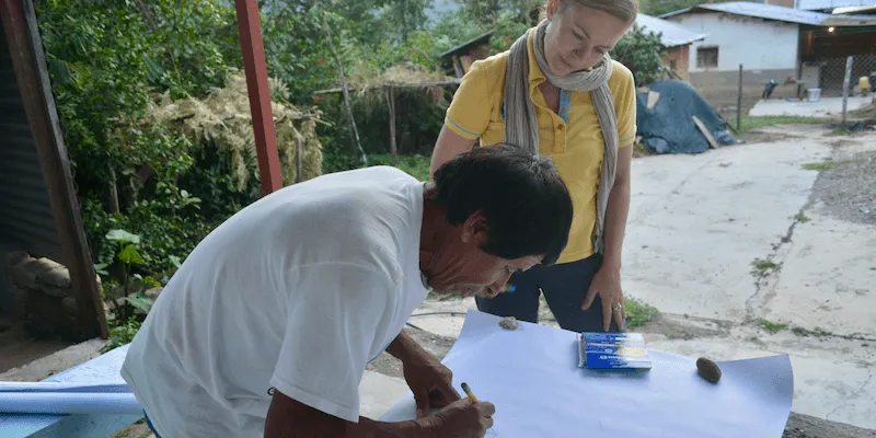 man drawing a map with woman looking over his shoulder