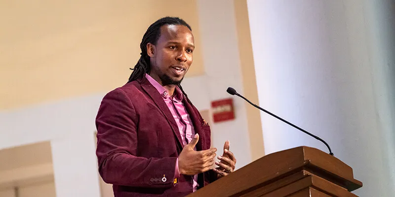 Ibram X. Kendi speaks at a lecturn at the University of Vermont