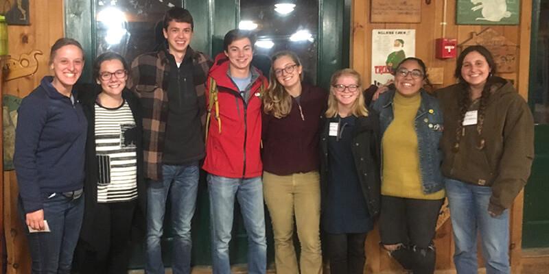 Eight students stand in the Hulbert Outdoor Center in Fairlee, Vermont.