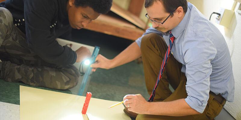 Teacher engages student in shadow experiment.