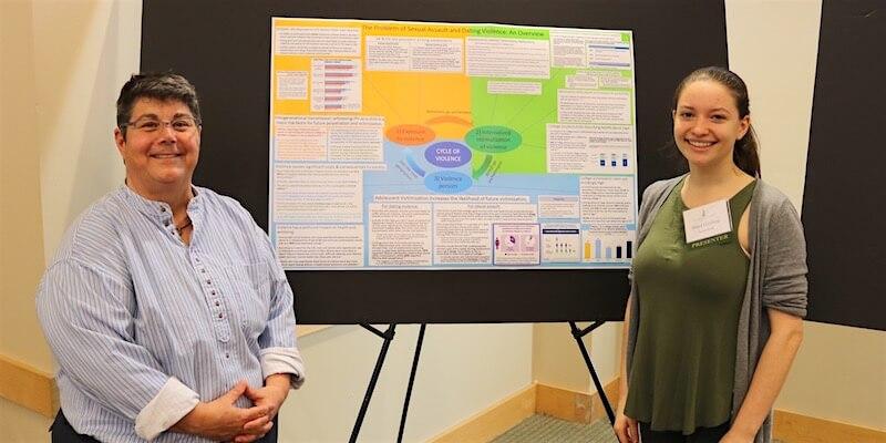 At the UVM Student Research Conference, Shaya Ginsberg (right) with her project advisor JB Barna, senior lecturer in the Department of Social Work at UVM.