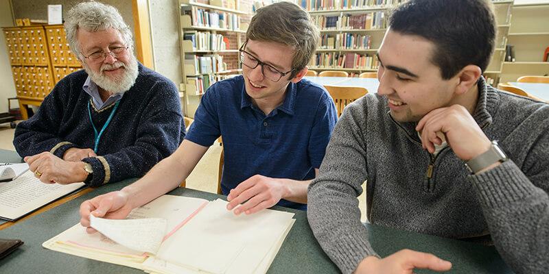 Steve Terry and students look at papers in UVM's Special Collections