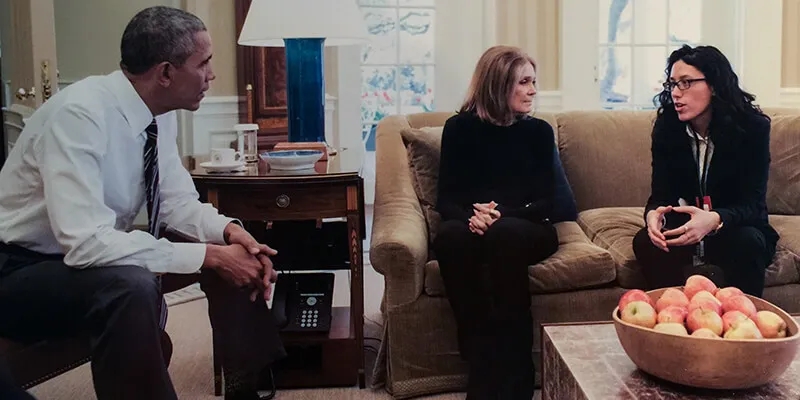 President Barack Obama, Gloria Steinem and Ariel Wengroff sit in the Oval Office, talking.