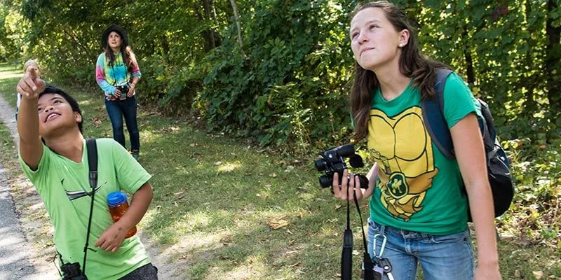  Tobey, a fourth-grader at JJ Flynn Elementary School watches birds over the bike path in Burlington, VT, with his UVM mentor and “bird buddy,” Sara Fergus, a UVM sophomore enrolled in Environmental Studies 295, “Birding to Change the World.”