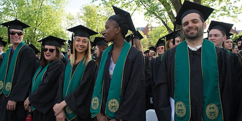 graduates stand on the UVM Green