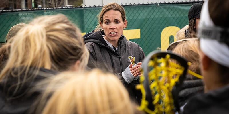 Women's lacrosse coach Sarah Dalton talks to University of Vermont student athletes
