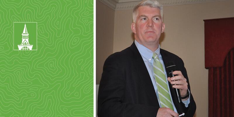 Jim Gildea with a microphone at a town meeting.