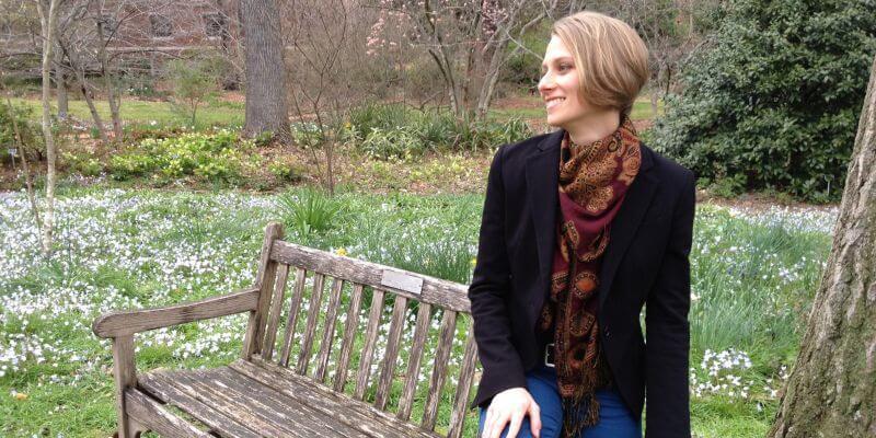 Kate Nolfi seated on a bench on UVM Campus
