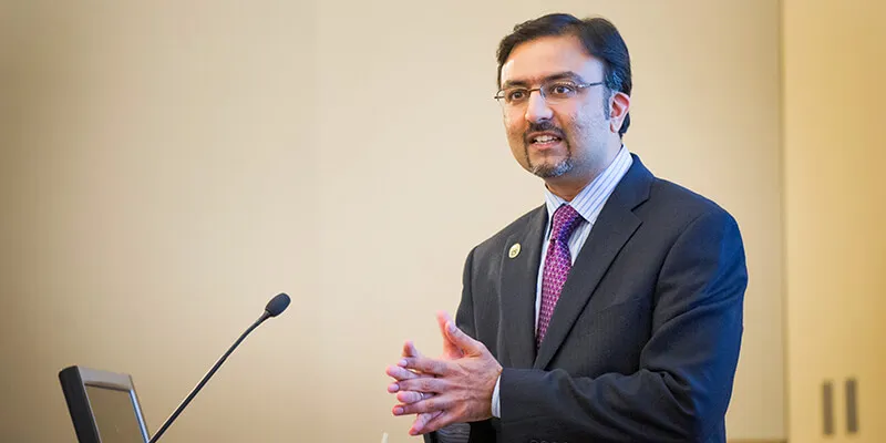 Dr. Omar Khan speaking at a podium