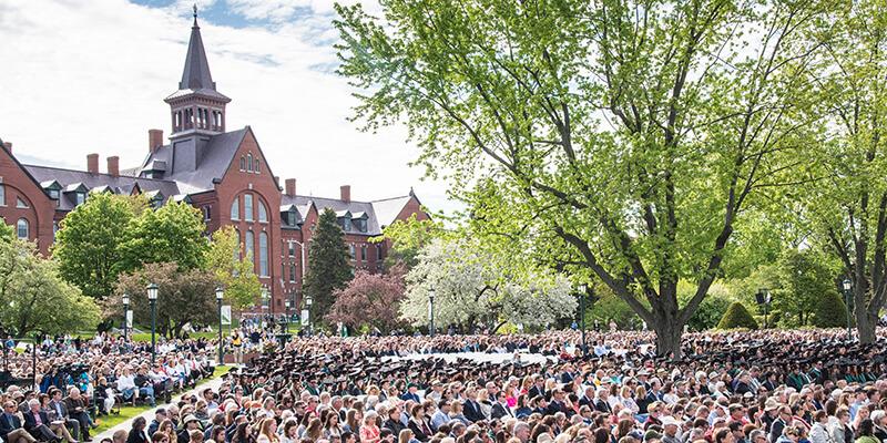 Graduates sit in front of Old Mill