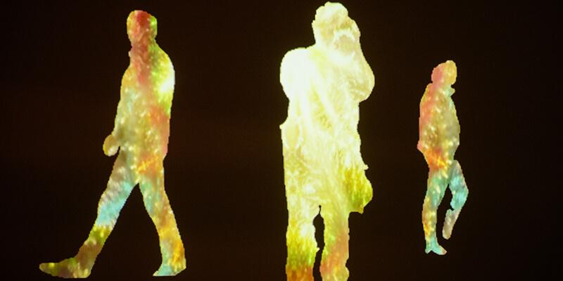 Three silhoutted figures against a black background