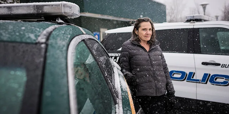 Stephanie Seguino outside a police car in snow