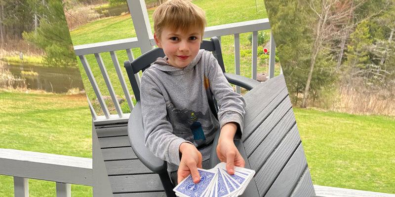 Boy holding playing cards.