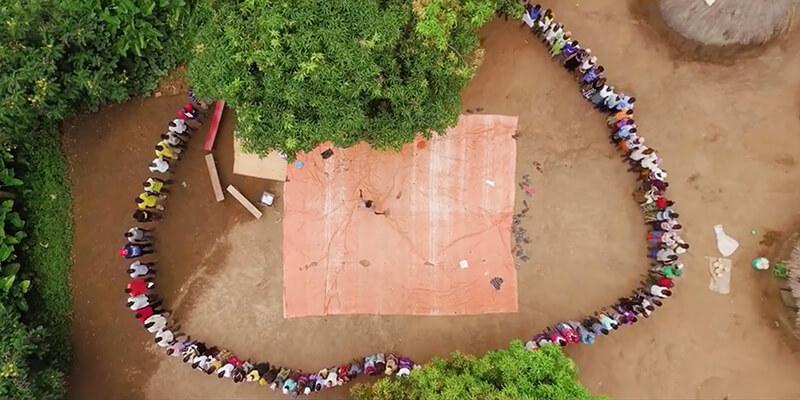 An aerial view of villagers standing in a circle