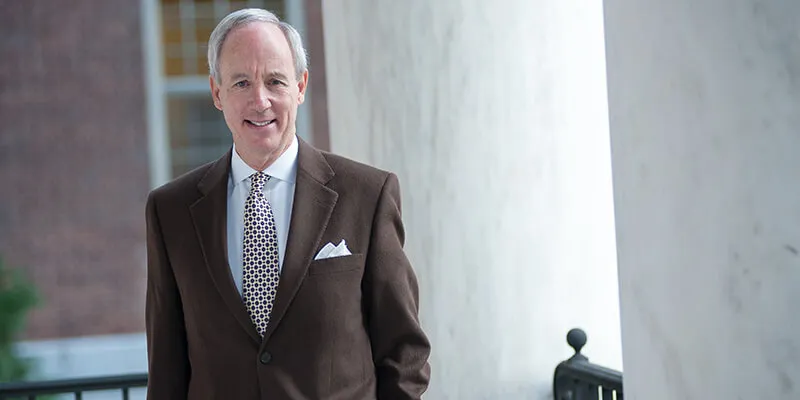 President Tom Sullivan stands on the steps to Waterman