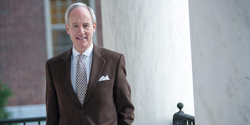 President Tom Sullivan stands on the steps to Waterman