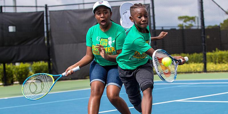 Two children play tennis