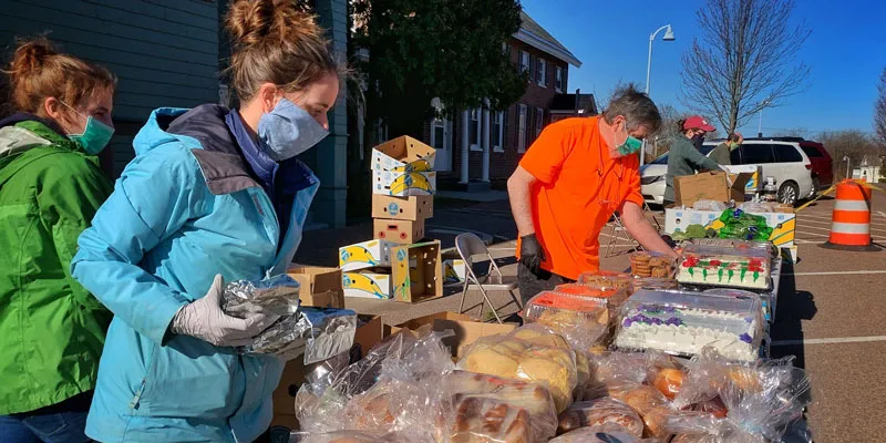 Volunteers at the Winooski Food Shelf follow new COVID-19 safety protocols and arrange a Saturday food pick-up program outdoors.