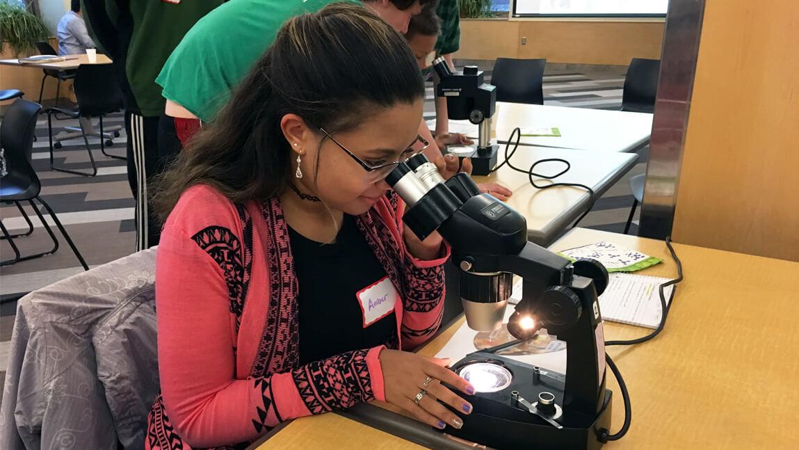 Girl looking into microscope