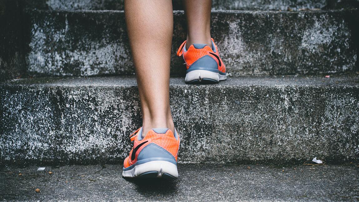 someone in sneakers running up concrete stairs