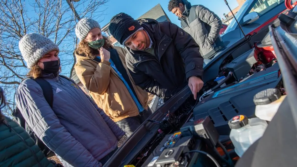 people looking at EV engine