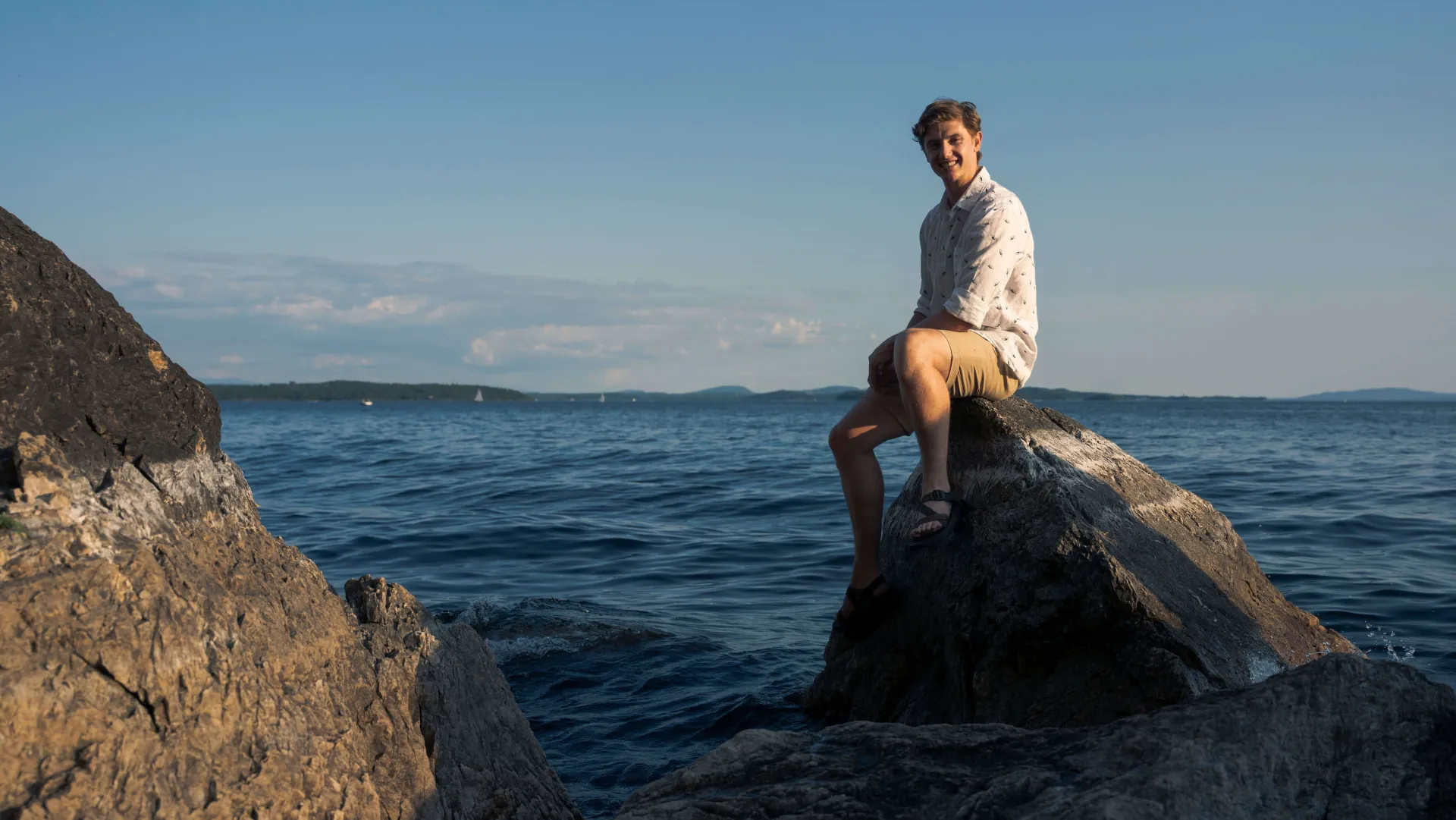 Andrew McCracken sits on the edge of Lake Champlain 