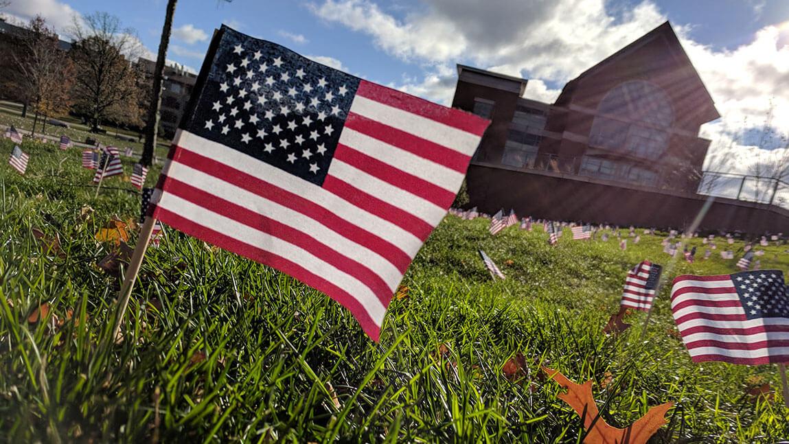 A United States flag staked in the lawn among many others near the Davis Center.