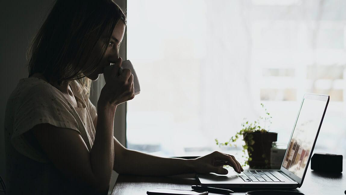 Lady at a laptop drinking coffee