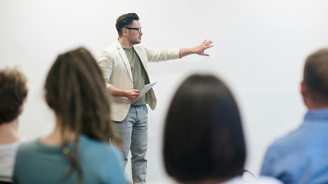 4 people watch one person lecturing and gesticulating