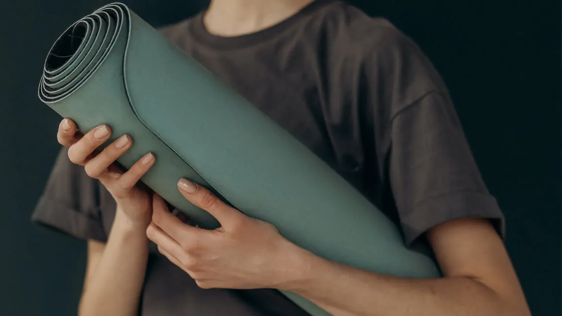 teen holding a yoga mat
