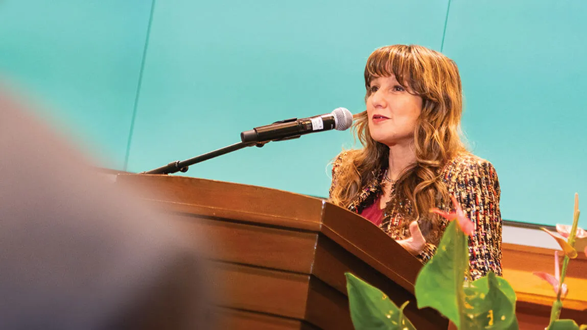 zeynep speaking at a podium with a green background