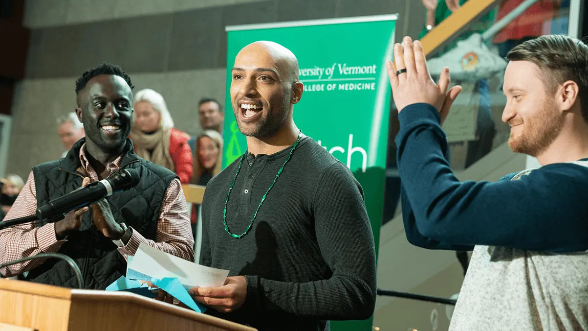 A medical student stands at a podium and reads his match letter