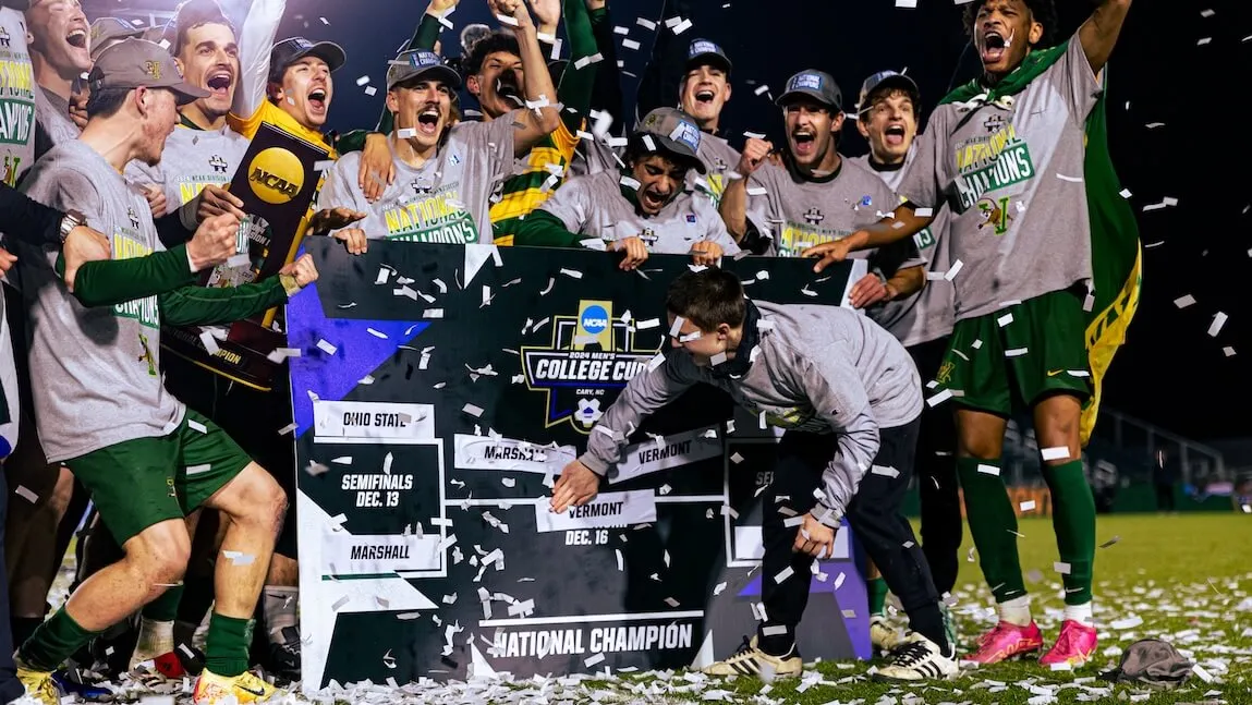 A group of UVM soccer players celebrate on filed after their victory