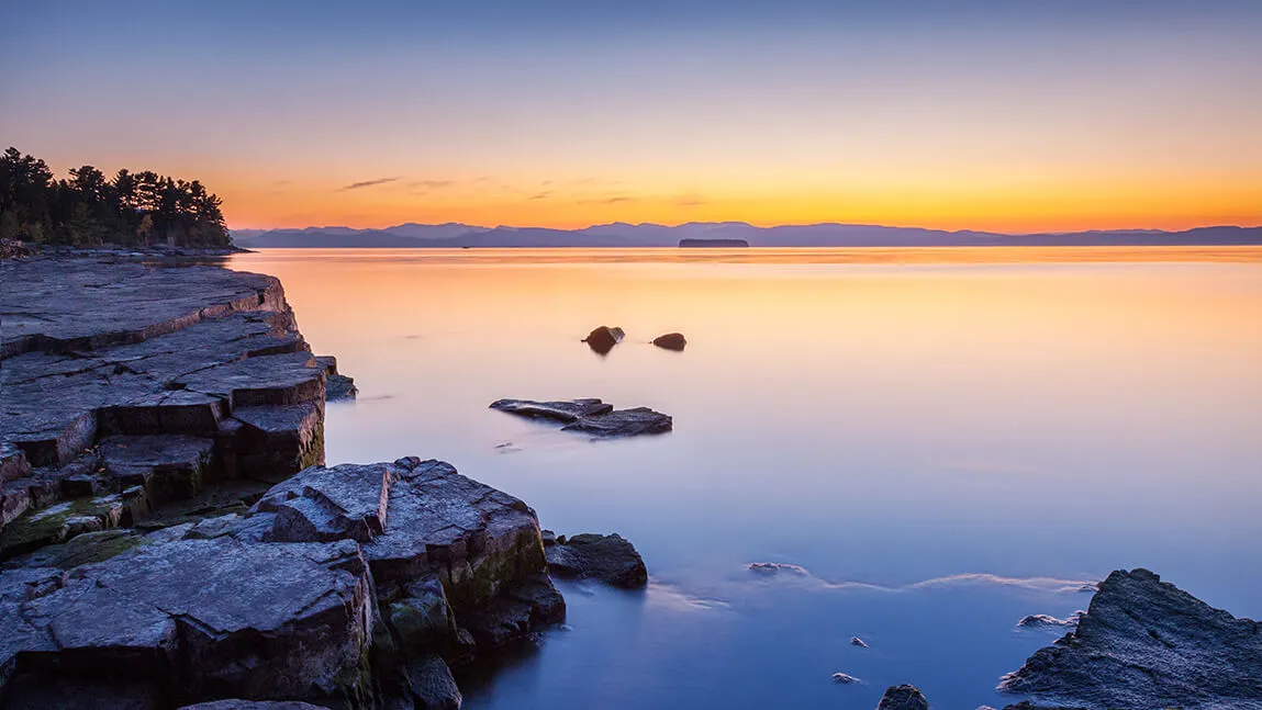 The sun rises over Lake Champlain.