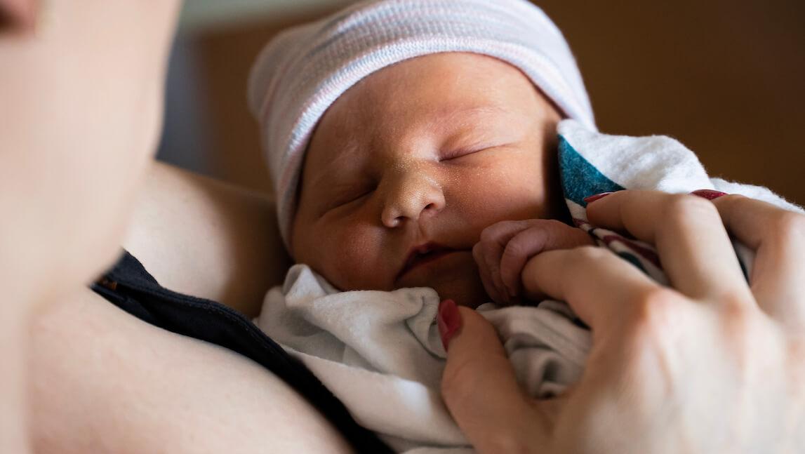 A woman holds a newborn baby