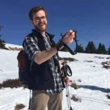 A person holding camera in a snowy mountain