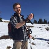 A person holding camera in a snowy mountain